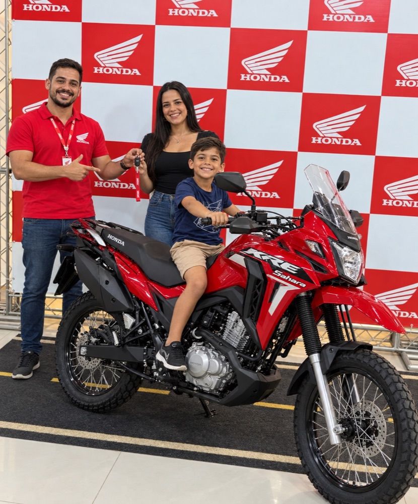 Camila Oliveira e o filho recebendo a chave da Honda XRE Sahara na concessionária